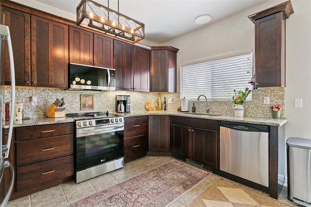 3618 Boot Spur Ct, Colorado Springs, CO 80922 - kitchen featuring stainless steel appliances, a sink, decorative backsplash, light stone countertops, and light tile patterned floors