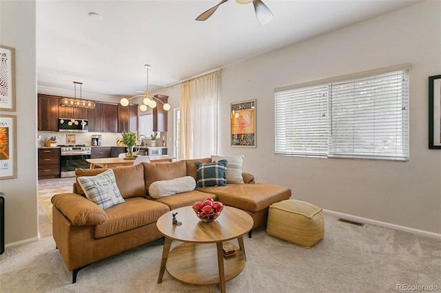 3618 Boot Spur Ct, Colorado Springs, CO 80922 - living area featuring a ceiling fan, light carpet, baseboards, and a chandelier