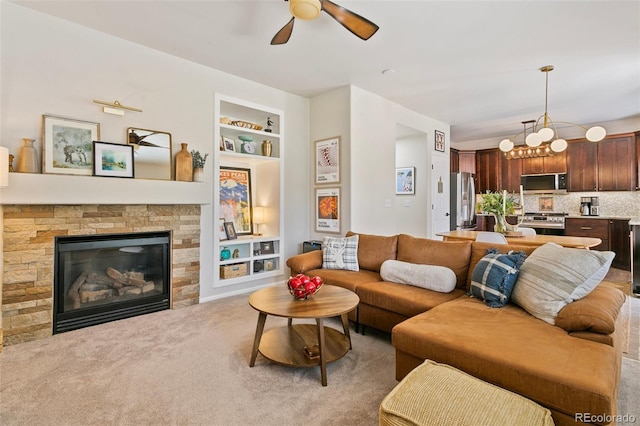 3618 Boot Spur Ct, Colorado Springs, CO 80922 - carpeted living room with built in features, ceiling fan, a fireplace, and a chandelier