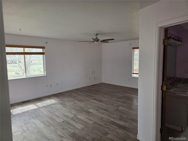 unfurnished room featuring wood finished floors, a ceiling fan, and baseboards