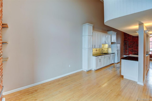 kitchen with white cabinetry, white refrigerator, sink, and tasteful backsplash