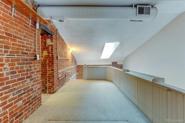 bonus room featuring light colored carpet, brick wall, and lofted ceiling with skylight