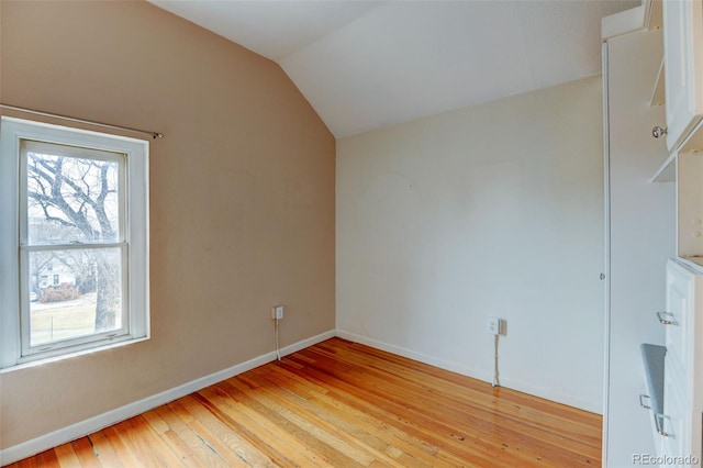 additional living space featuring vaulted ceiling and light wood-type flooring