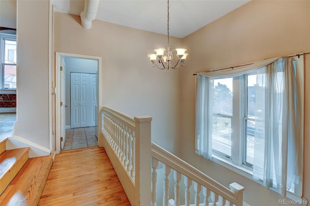 hallway featuring a notable chandelier and light wood-type flooring