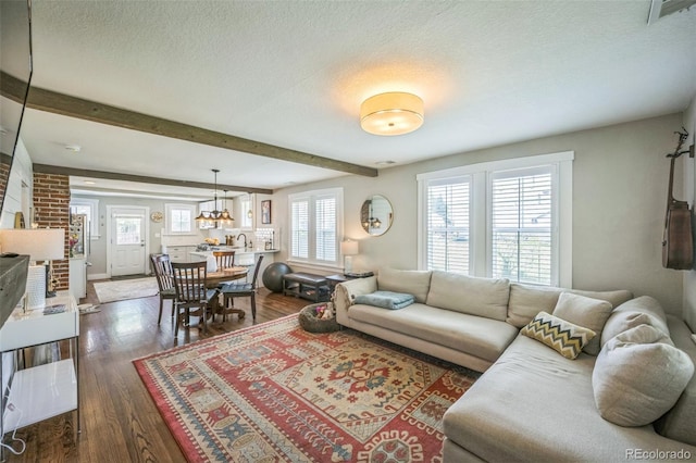 7340 W 32nd Ave, Wheat Ridge, CO 80033 - living room with dark wood-style flooring, a textured ceiling, beamed ceiling, and a chandelier