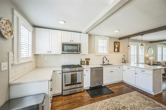 7340 W 32nd Ave, Wheat Ridge, CO 80033 - kitchen featuring appliances with stainless steel finishes, beamed ceiling, a peninsula, backsplash, and white cabinetry