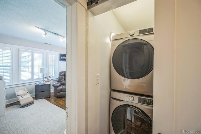 7340 W 32nd Ave, Wheat Ridge, CO 80033 - laundry room featuring stacked washer / drying machine, rail lighting, and carpet