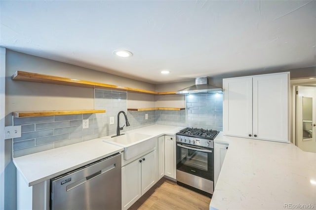 7340 W 32nd Ave, Wheat Ridge, CO 80033 - kitchen with open shelves, stainless steel appliances, wall chimney range hood, white cabinets, and tasteful backsplash