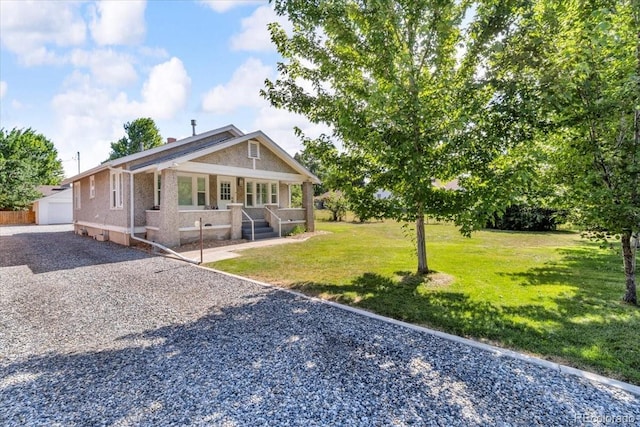 7340 W 32nd Ave, Wheat Ridge, CO 80033 - view of front of house with covered porch, an outdoor structure, and a front yard