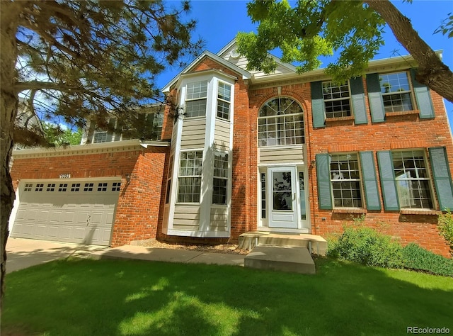 15292 E Hialeah Pl, Aurora, CO 80015 - view of front facade featuring brick siding, a garage, driveway, and a front lawn