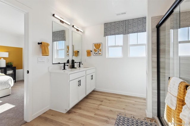 22203 E 6th Pl, Aurora, CO 80018 - full bath with double vanity, wood finished floors, baseboards, and an enclosed shower