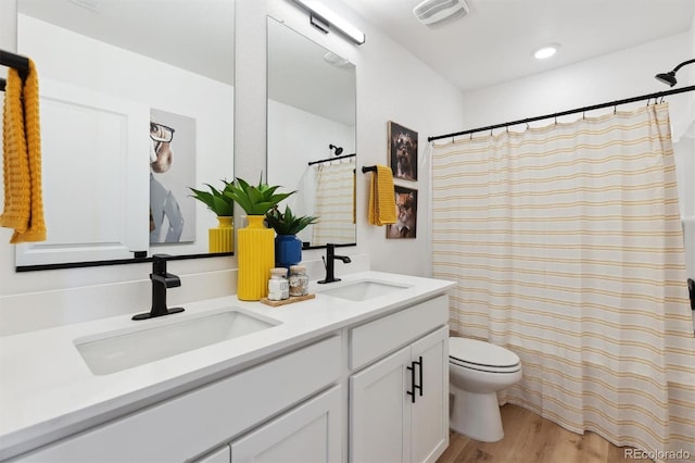 22203 E 6th Pl, Aurora, CO 80018 - bathroom featuring double vanity, toilet, wood finished floors, and a shower with curtain