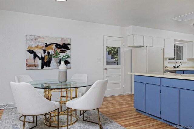 dining area featuring light wood-style flooring, attic access, and visible vents