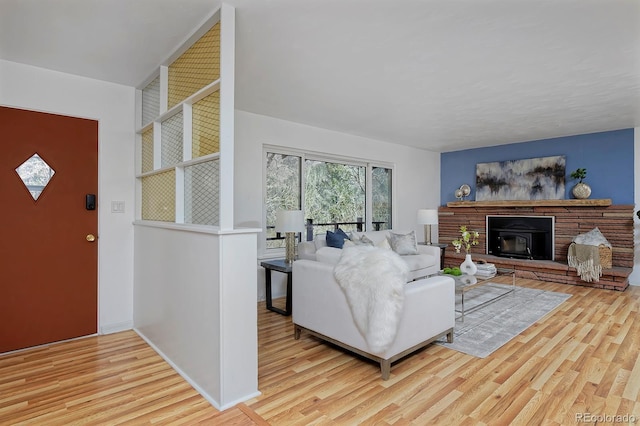 living room with a glass covered fireplace, baseboards, and wood finished floors