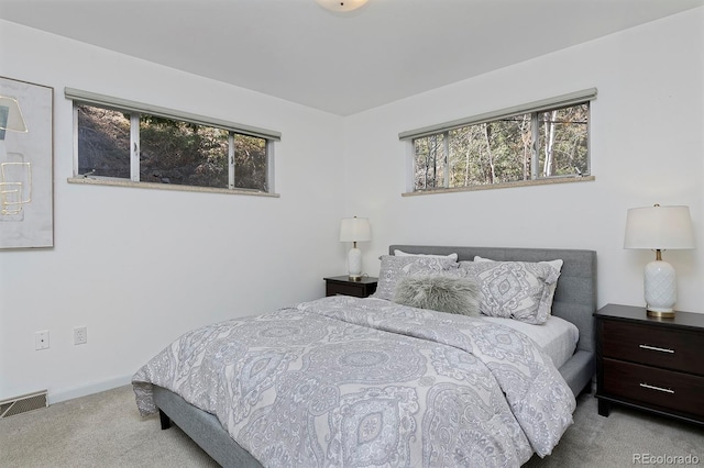 carpeted bedroom featuring baseboards and visible vents