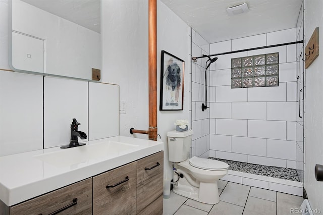bathroom featuring toilet, vanity, tile patterned floors, and a shower stall
