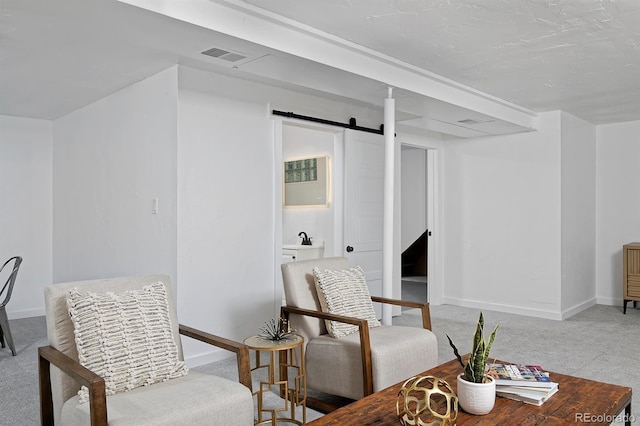 living area with baseboards, a barn door, carpet flooring, and visible vents