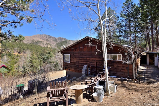 back of property featuring an outdoor structure and a mountain view