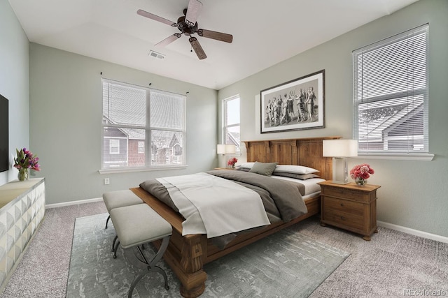 carpeted bedroom featuring ceiling fan, visible vents, and baseboards