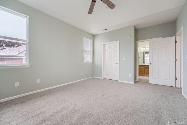 unfurnished bedroom with carpet floors, multiple windows, a ceiling fan, and baseboards