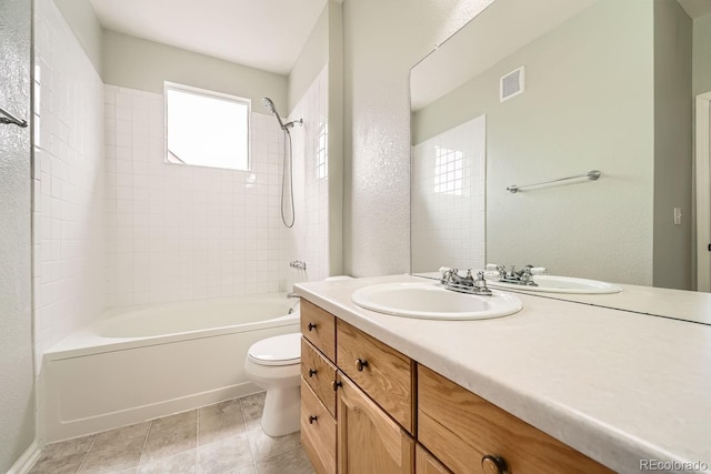 full bathroom with visible vents, a textured wall, toilet, bathing tub / shower combination, and vanity