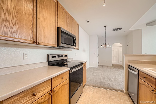 kitchen featuring light carpet, stainless steel appliances, visible vents, light countertops, and decorative light fixtures