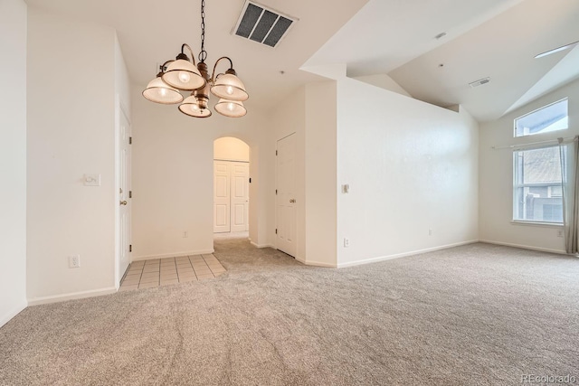 empty room with arched walkways, carpet, a chandelier, and visible vents