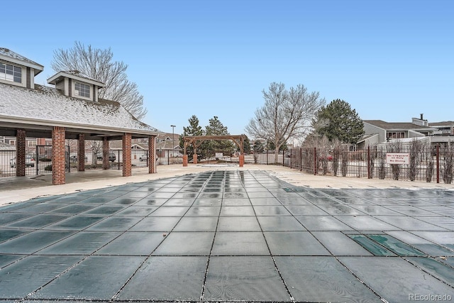 community pool with a patio and fence