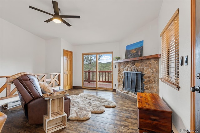 living area featuring a ceiling fan, hardwood / wood-style flooring, and a fireplace