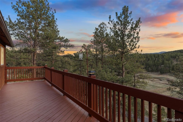 deck at dusk with a view of trees