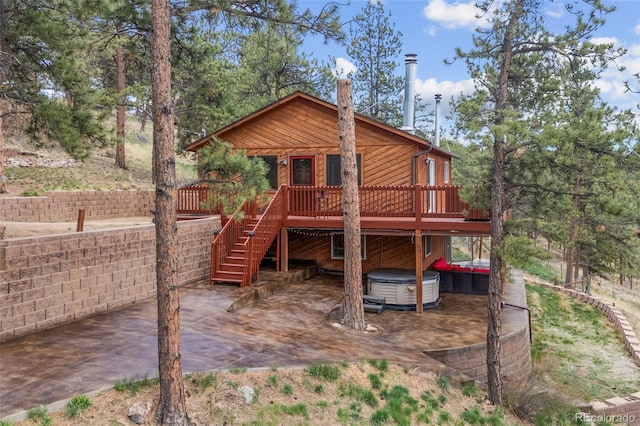 view of jungle gym with a patio, a hot tub, a wooden deck, and stairway