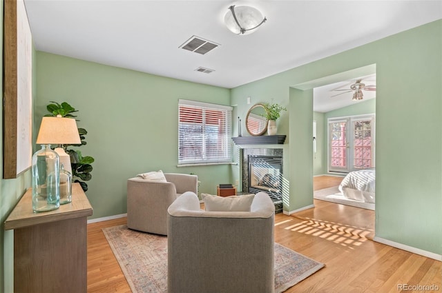 living area featuring ceiling fan, lofted ceiling, and light hardwood / wood-style floors