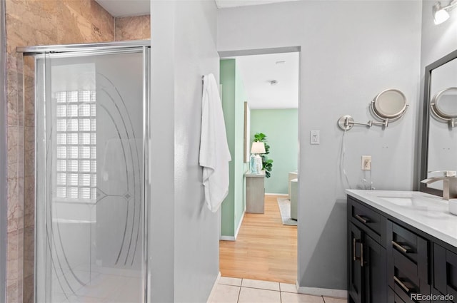 bathroom featuring tile patterned flooring, vanity, and a shower with shower door