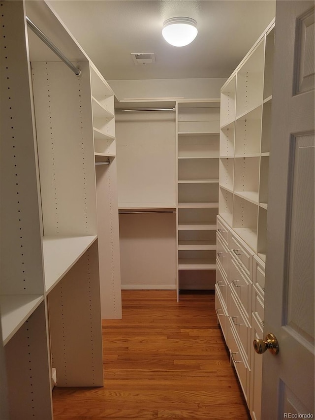 spacious closet with hardwood / wood-style flooring