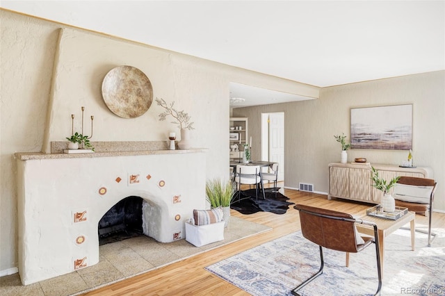 living area featuring visible vents, baseboards, and wood finished floors