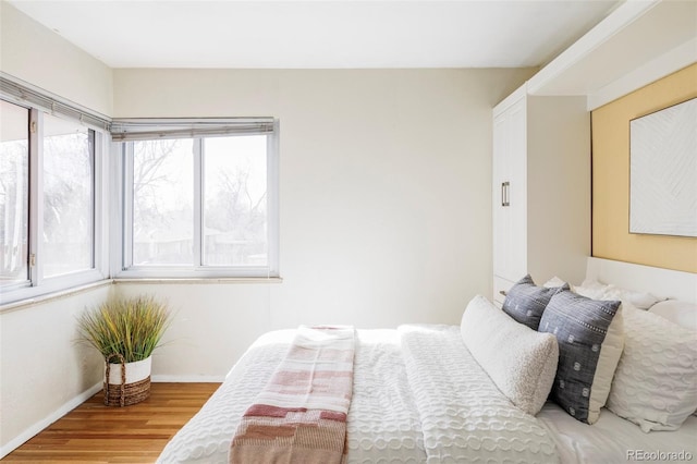 bedroom with baseboards and wood finished floors