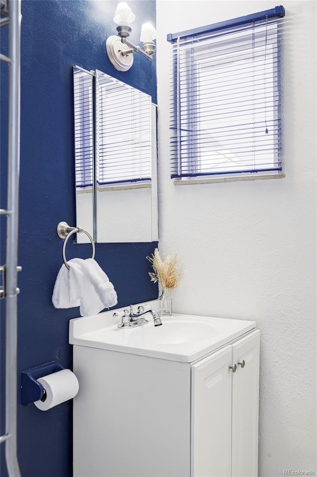 bathroom featuring vanity and a textured wall