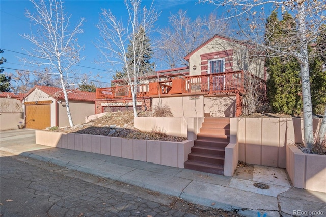 view of front of house featuring stairway, an outbuilding, and a wooden deck