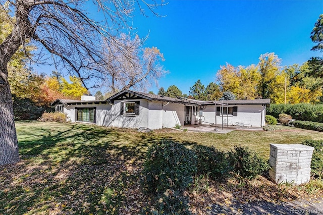 rear view of property with a yard and a patio area