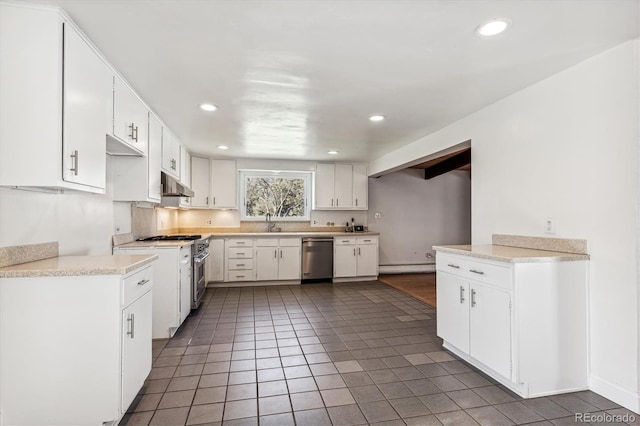 kitchen featuring dark tile patterned flooring, sink, white cabinetry, baseboard heating, and stainless steel dishwasher