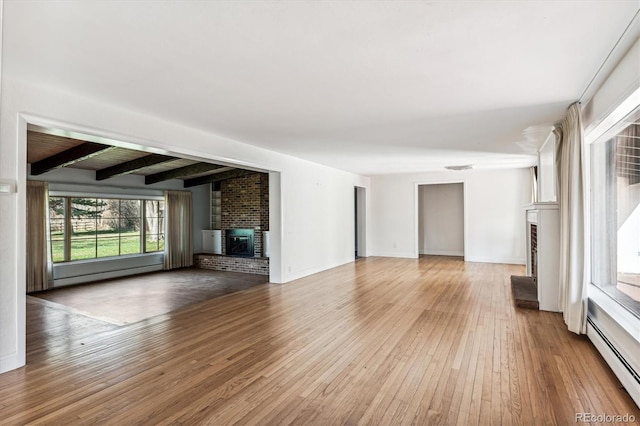 unfurnished living room featuring hardwood / wood-style floors, beam ceiling, a baseboard radiator, and a brick fireplace