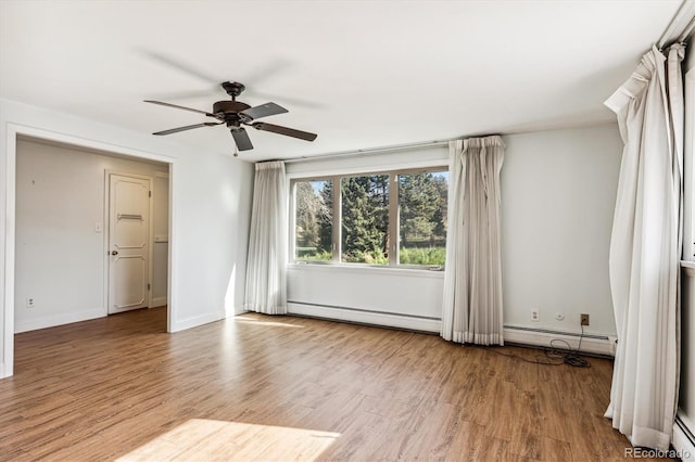 empty room with light hardwood / wood-style flooring, a baseboard heating unit, and ceiling fan