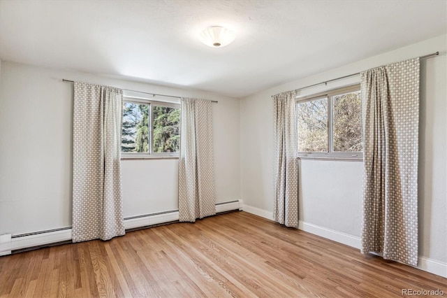 unfurnished bedroom with a baseboard radiator, multiple windows, and light hardwood / wood-style floors