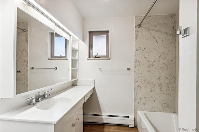 bathroom featuring vanity, a baseboard heating unit, hardwood / wood-style floors, and washtub / shower combination