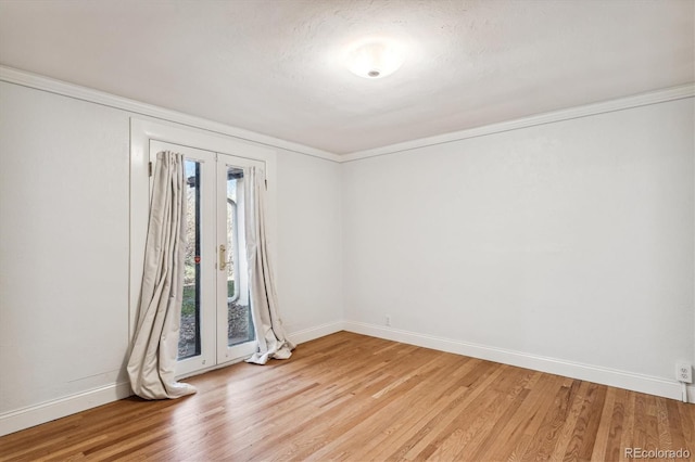 unfurnished room with ornamental molding and light wood-type flooring