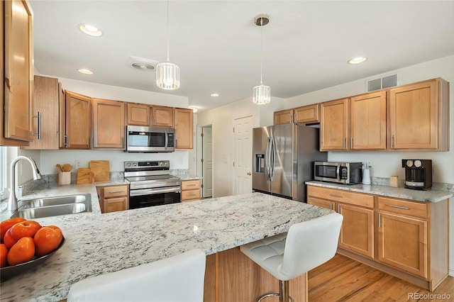 24285 E Wagon Trail Ave, Aurora, CO 80016 - kitchen with stainless steel appliances, a sink, a peninsula, hanging light fixtures, and recessed lighting