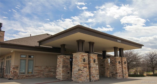 24285 E Wagon Trail Ave, Aurora, CO 80016 - view of side of home featuring stucco siding, a chimney, and stone siding