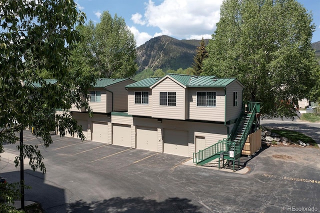 980 Lakepoint Dr Unit 1, Frisco, CO 80443 - view of front of property with a standing seam roof, stairway, a mountain view, an attached garage, and a metal roof