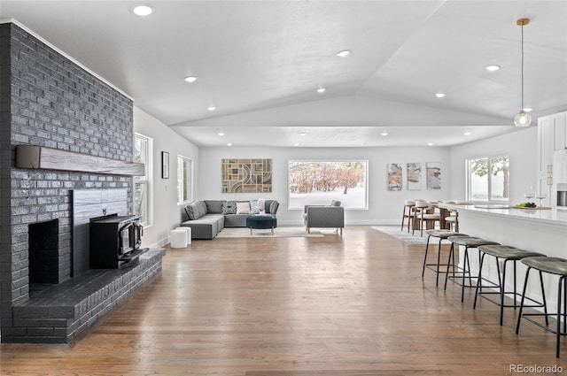 living room with hardwood / wood-style flooring, lofted ceiling, and a fireplace