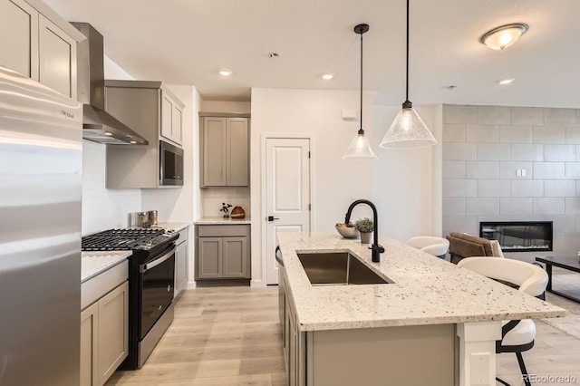 374 N Geneva, Aurora, CO 80010 - kitchen with appliances with stainless steel finishes, a sink, wall chimney exhaust hood, light wood-type flooring, and recessed lighting